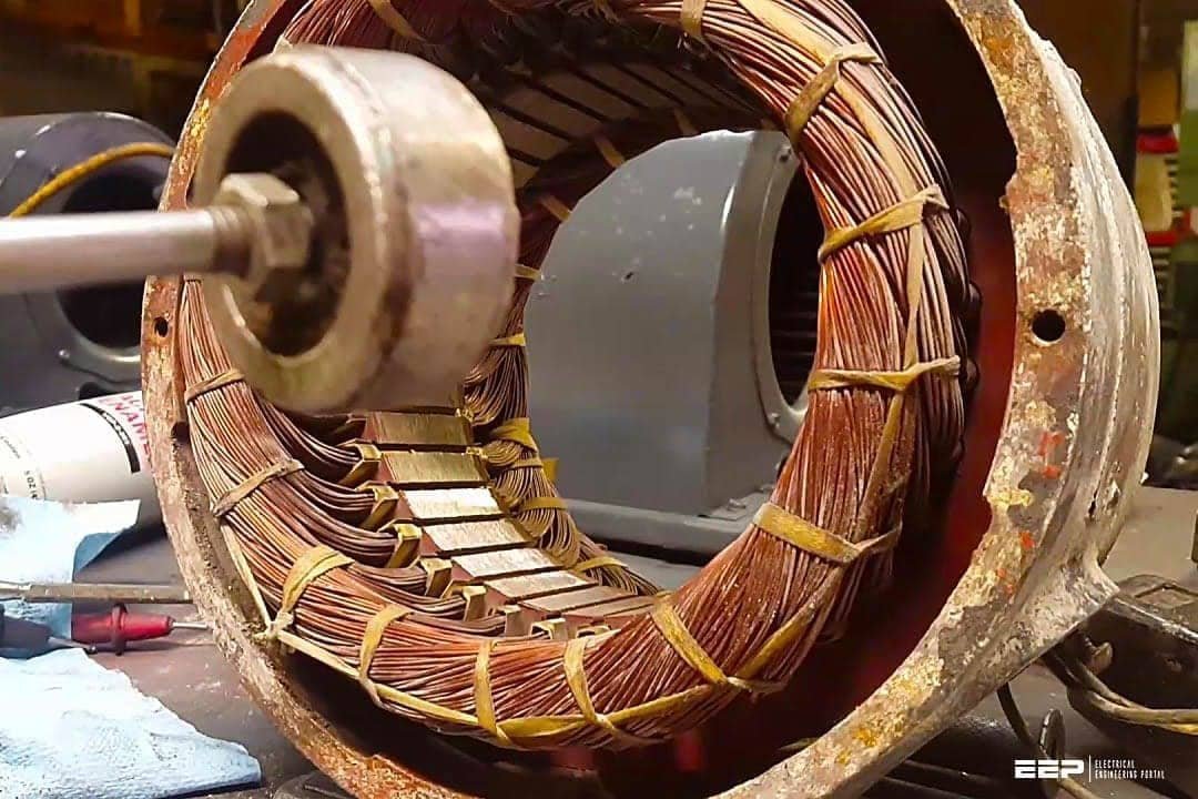 An open terminal box of a three-phase electric motor showing complex copper wiring.