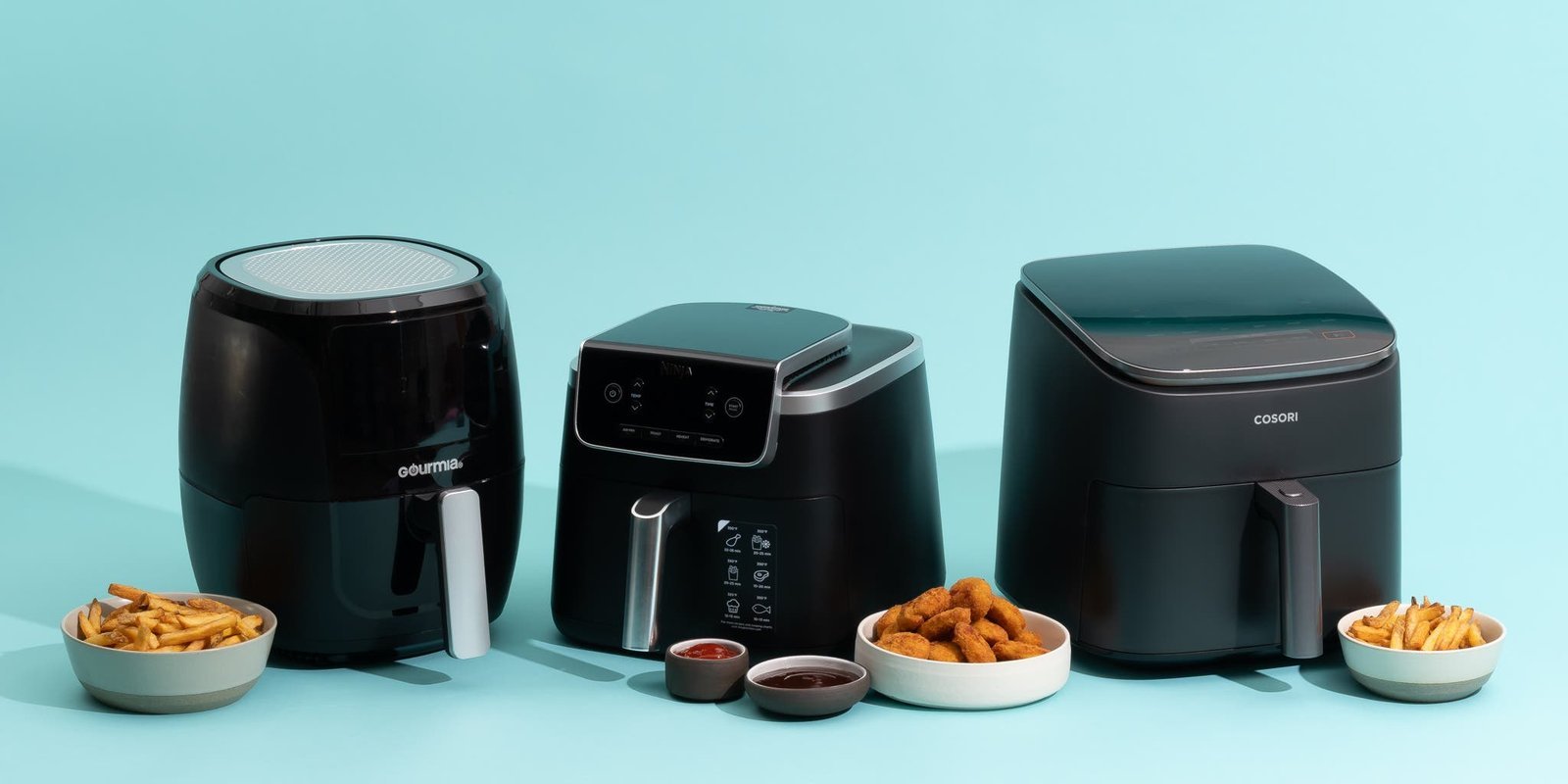 A modern air fryer sits on a kitchen counter next to crispy potato wedges.