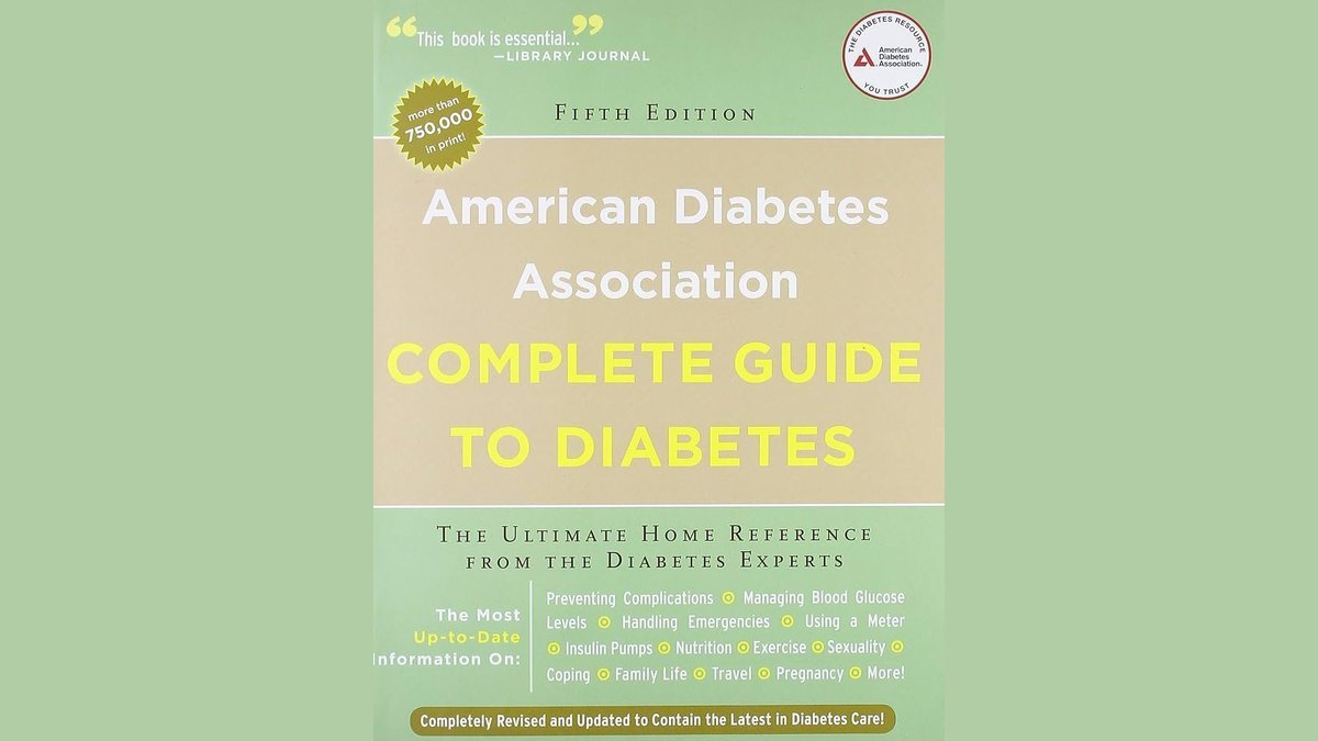 A collection of American Diabetes Association nutrition books next to fresh healthy fruit.