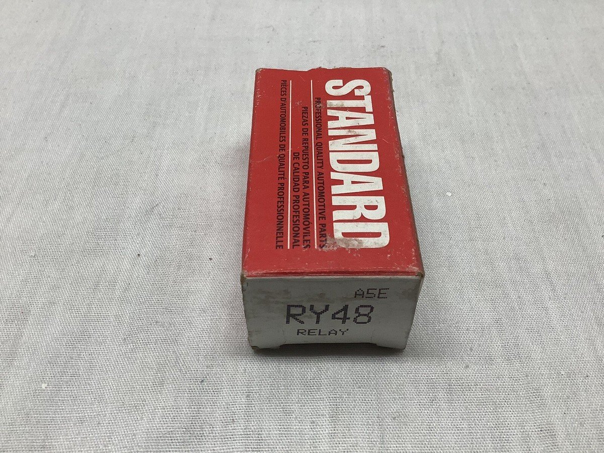 An automotive auxiliary heater relay sits on a workbench for electrical system maintenance.