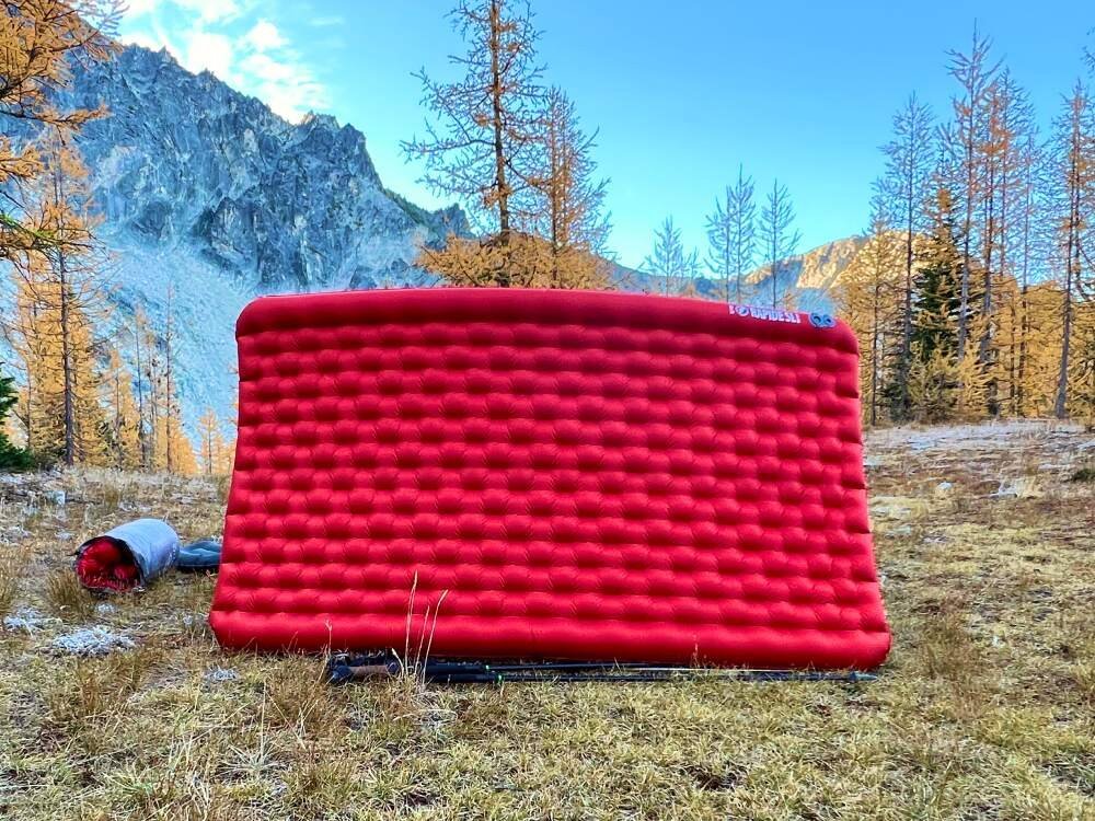 A comfortable double sleeping pad inside a tent with mountain views for backpacking.