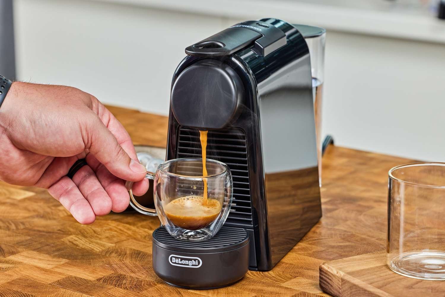 A compact espresso machine for small apartments sits on a bright kitchen counter.