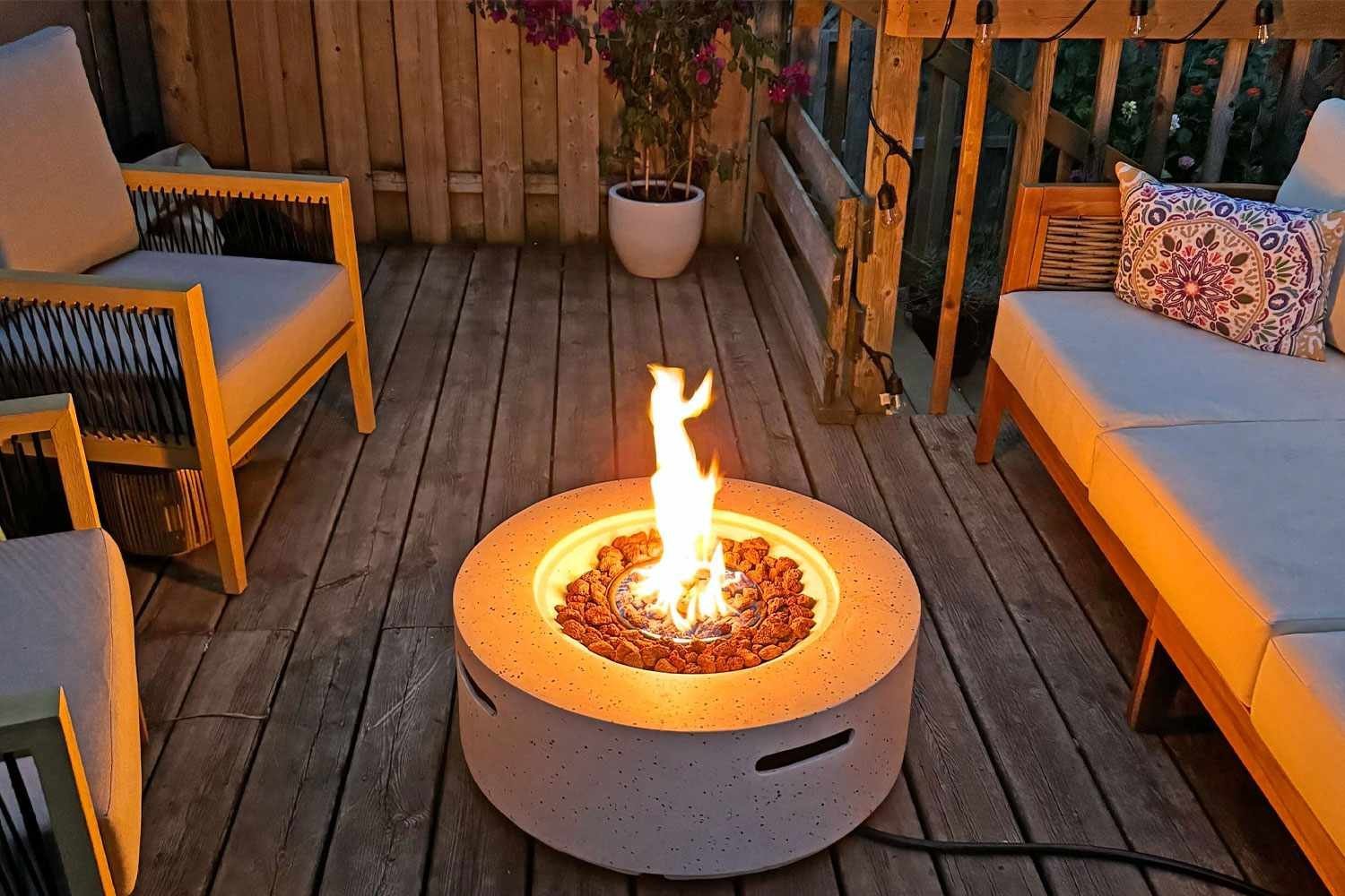 A modern propane fire pit creates a cozy atmosphere on a small patio.