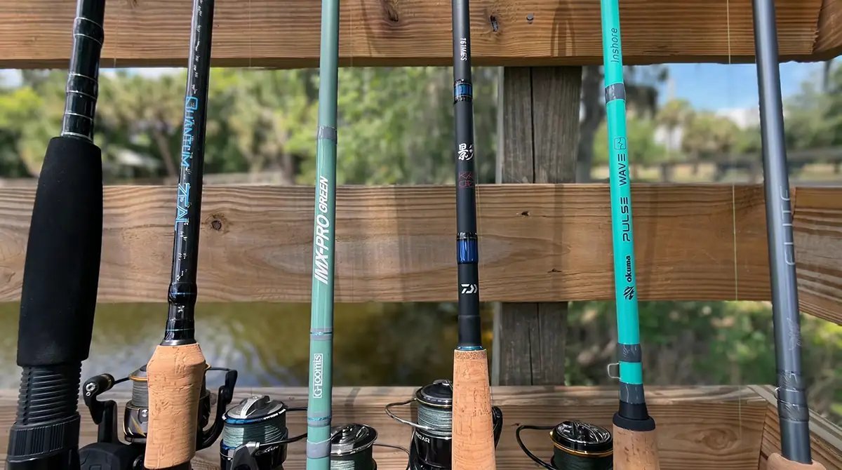 A high-quality saltwater fishing rod held on a pier at sunrise.