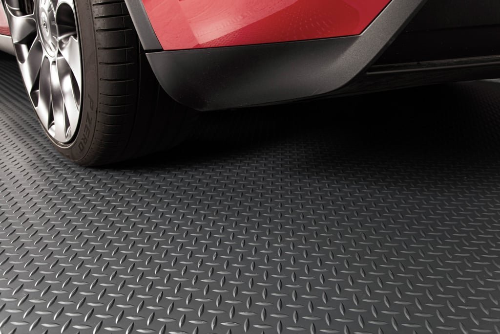 A durable garage floor parking mat protecting the concrete under a parked sedan.