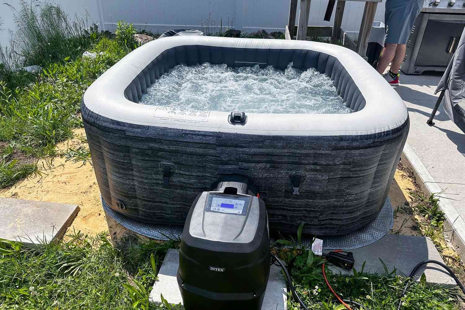An inviting inflatable hot tub steams on a snowy deck during winter evening.