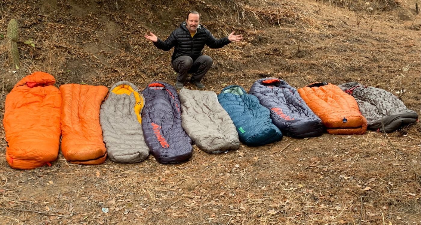 A lightweight sleeping bag laid out on a mountain ridge during sunrise.