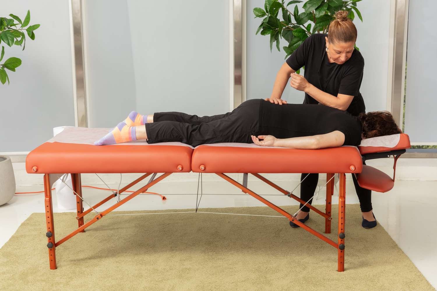 A professional massage table stands in a bright, modern spa wellness room.
