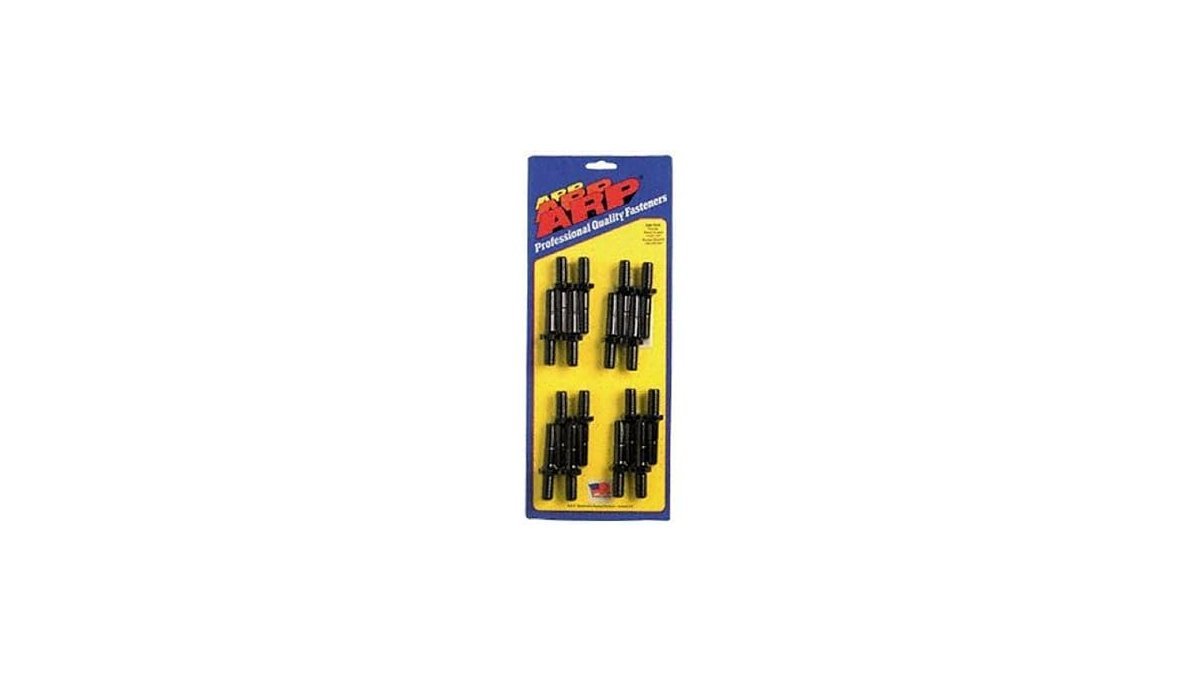 A collection of high-performance rocker arm nuts and bolts displayed on a workbench.