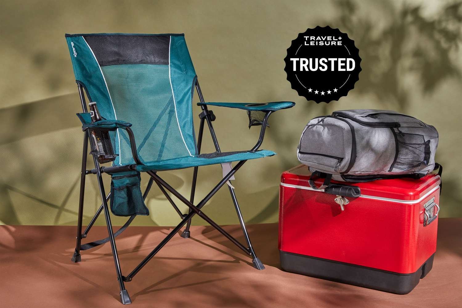 A portable folding chair set up on grass for watching a sporting event.