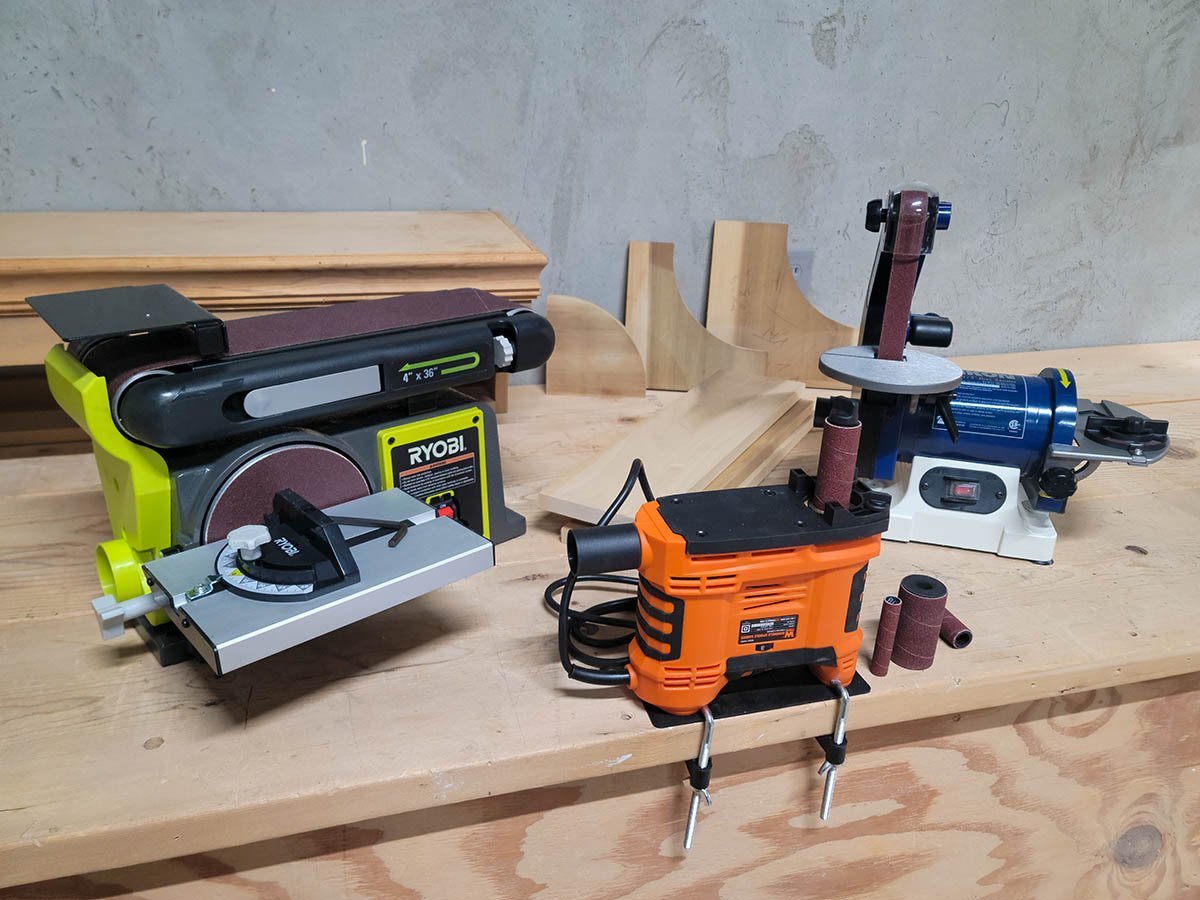 A professional combination disc belt sander sits on a workbench in a bright workshop.