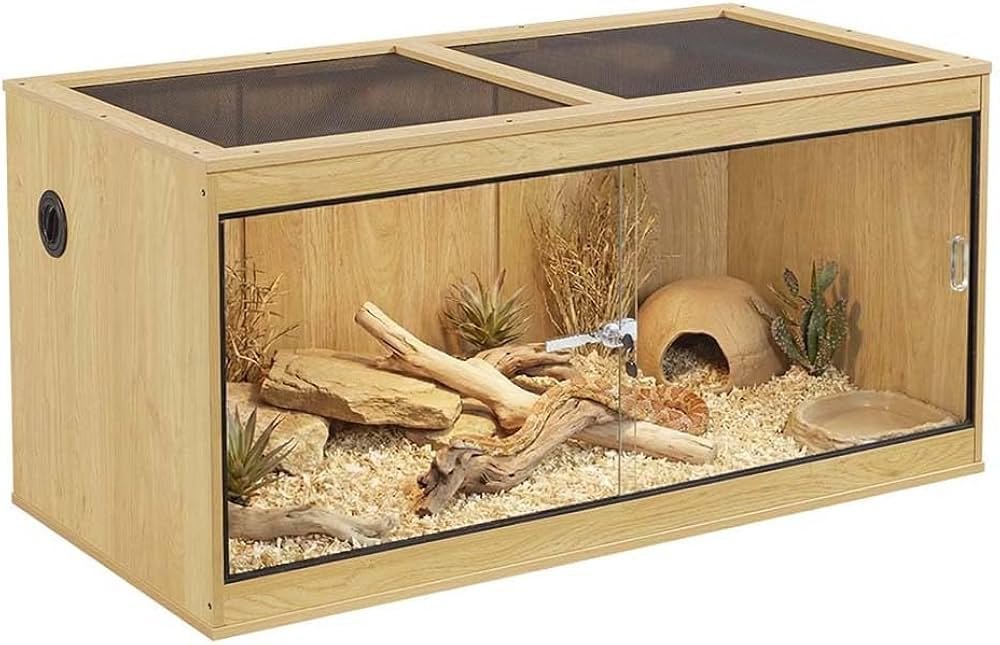 A modern glass reptile tank with sliding doors displayed in a bright living room.
