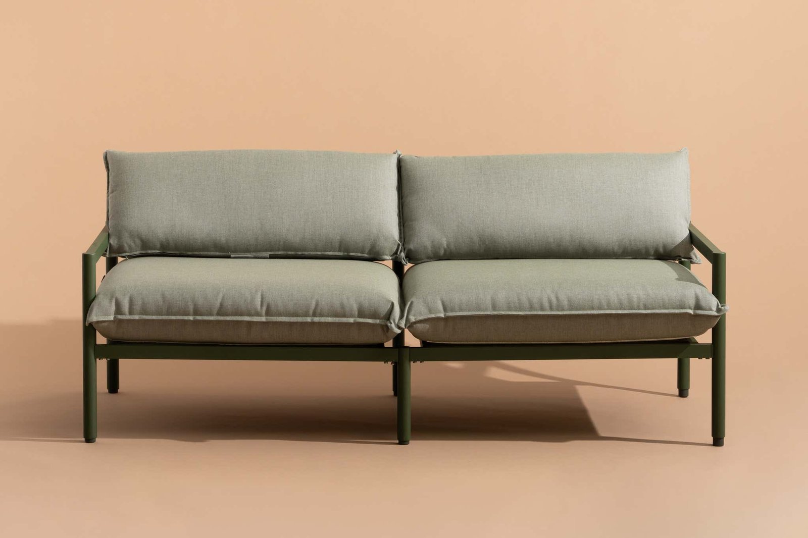 A modern waterproof outdoor sofa sits elegantly on a quiet garden patio.