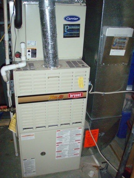 Exterior PVC exhaust and intake vents for a furnace showing potential debris blockages.