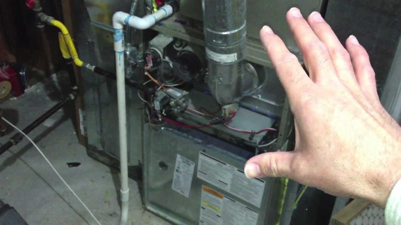 A technician inspects the complex internal components of a Bryant Plus 90t furnace.