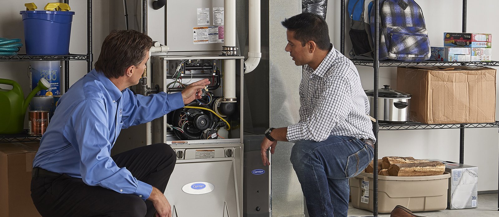 A technician performs Carrier furnace manual troubleshooting on an open residential heating unit.
