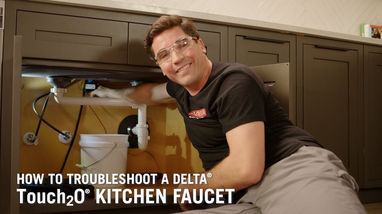 The sensor base of a touchless faucet is visible in a clean kitchen.