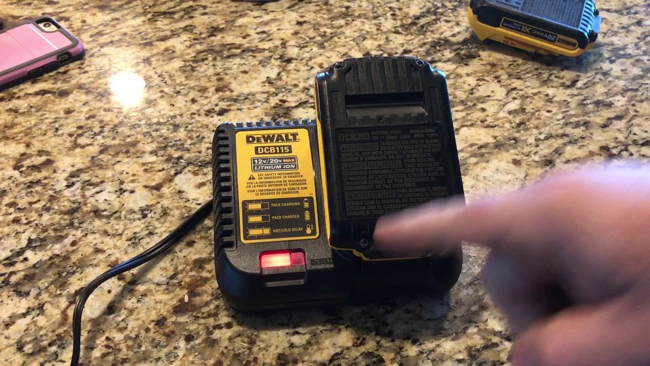 A professional tool battery being inserted into a charger for Dewalt battery charger troubleshooting.