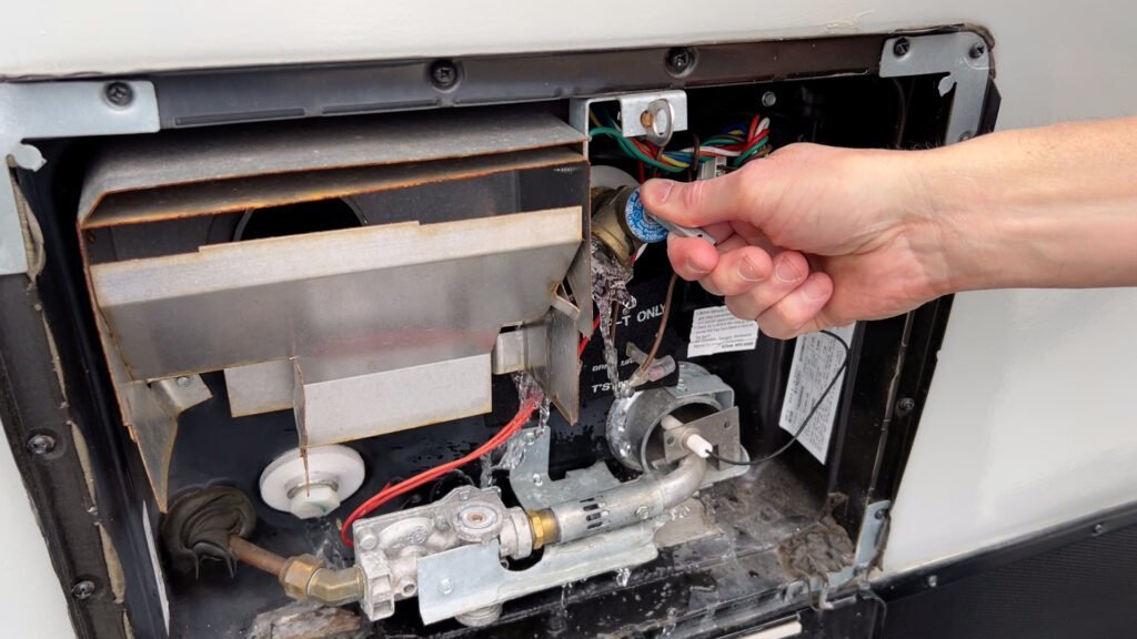 Close-up of internal wiring behind a Dometic RV thermostat wall plate.