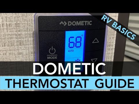 Using a multimeter to verify power to an RV thermostat display.