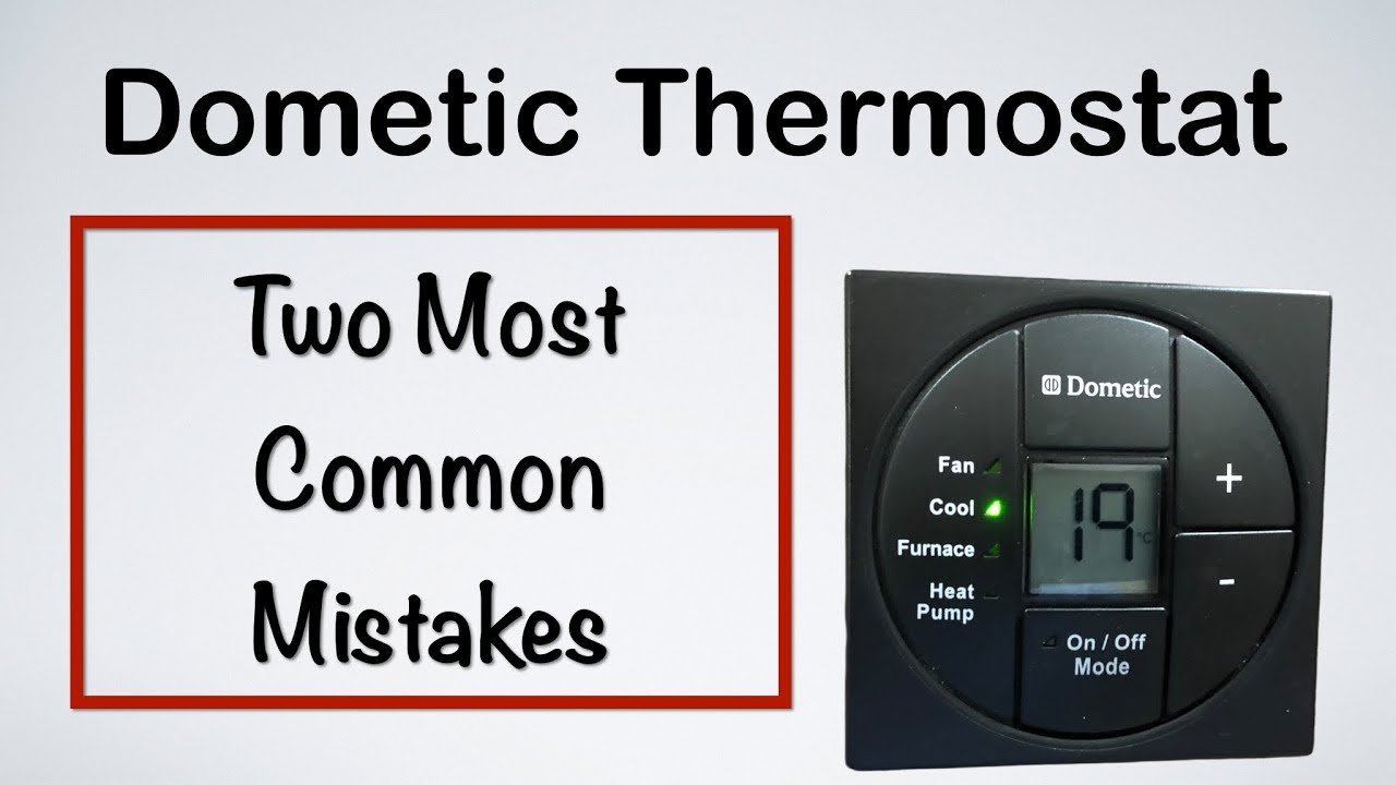 A modern Dometic RV thermostat mounted on a wall inside a recreational vehicle.