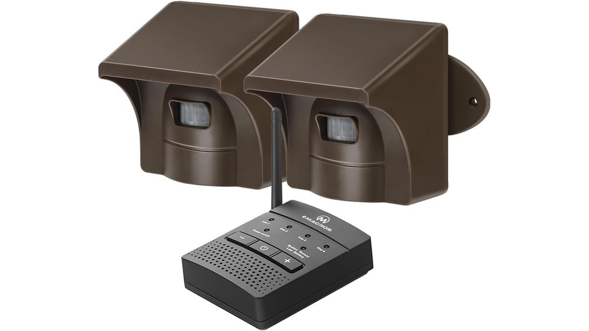 A wireless driveway alarm sensor mounted near a suburban home for security monitoring.