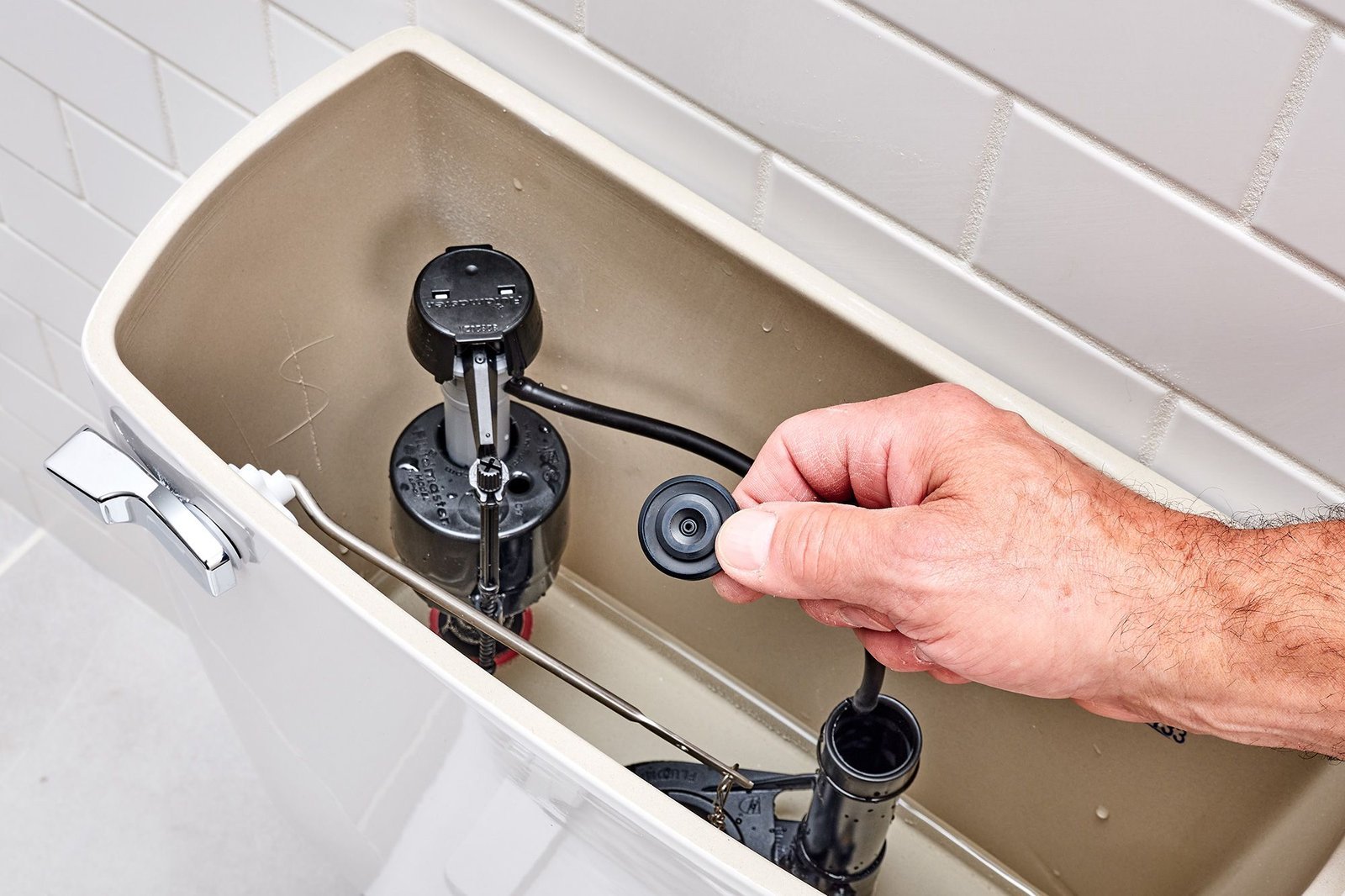 A close-up view of a Fluidmaster fill valve inside a clean toilet tank.