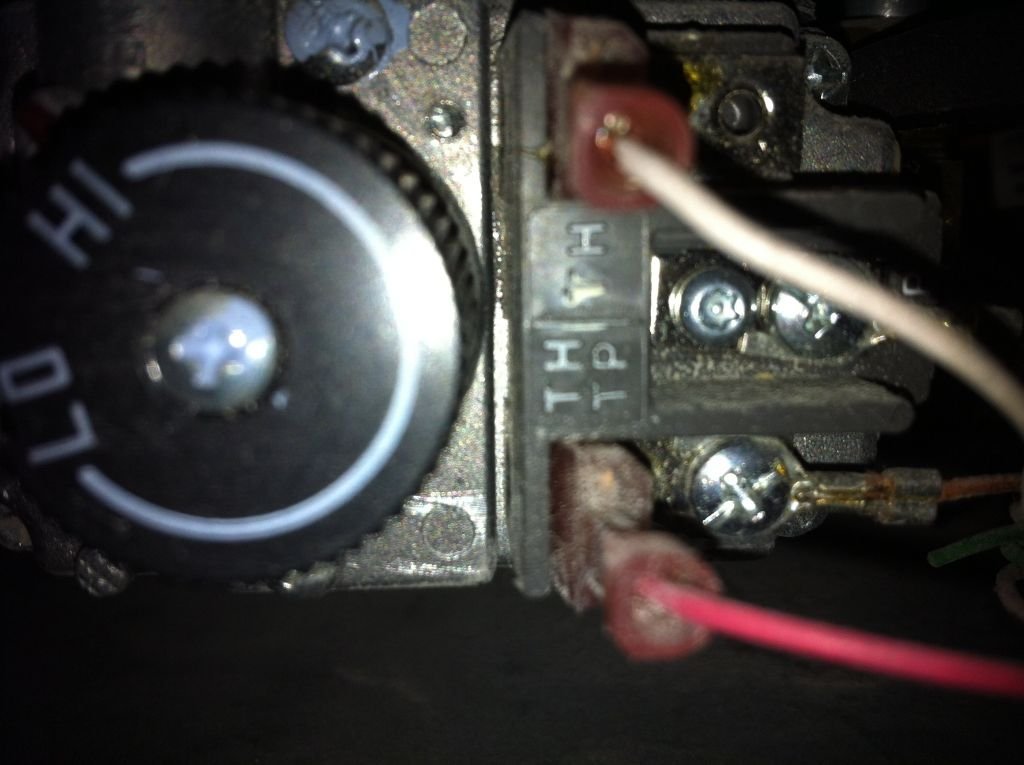 A brass gas shut off valve in the open position near a fireplace.