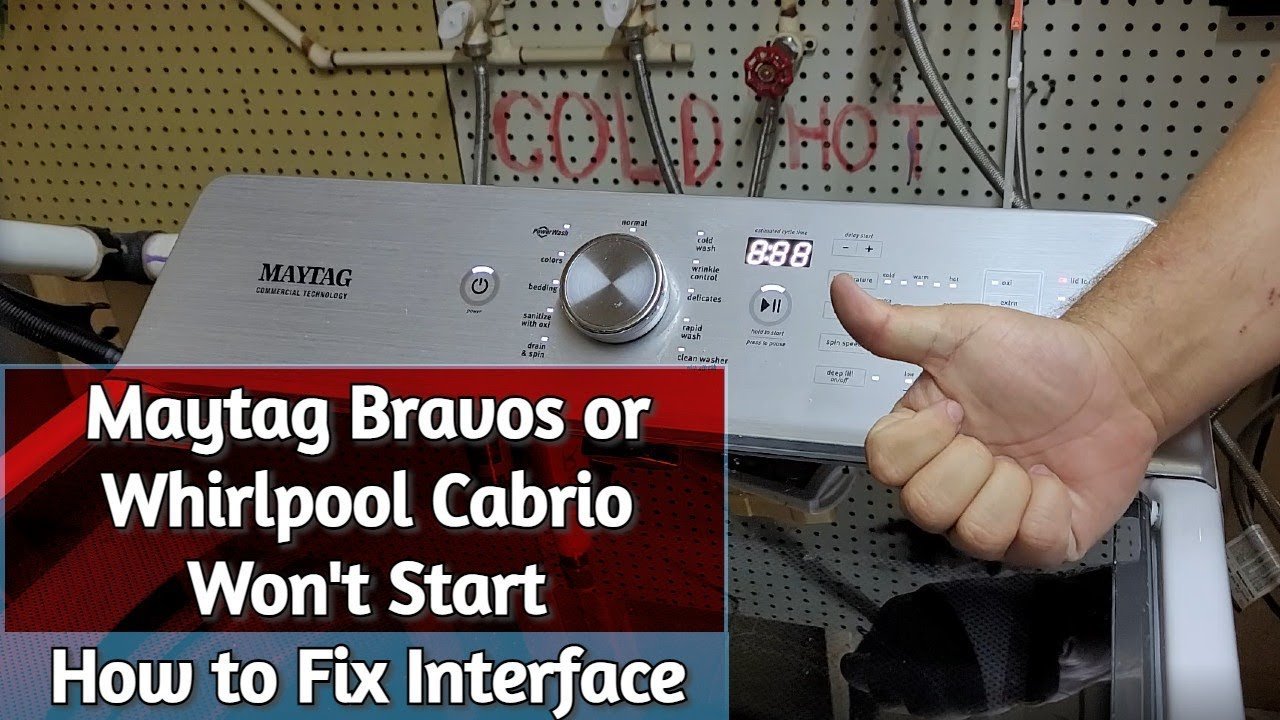 Hands straightening a kinked drain hose behind a Maytag Bravos washer.