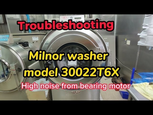 A professional Milnor washing machine stands in a clean, modern commercial laundry facility.