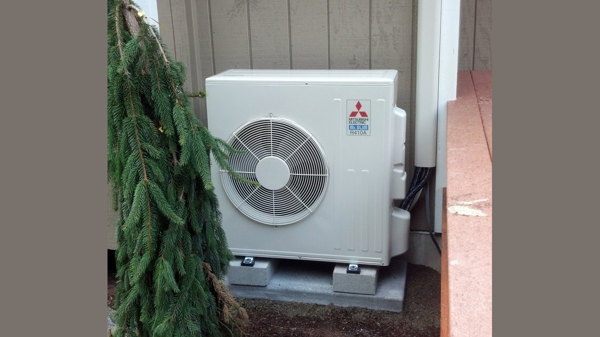 A modern Mitsubishi mini split unit mounted on a clean white living room wall.