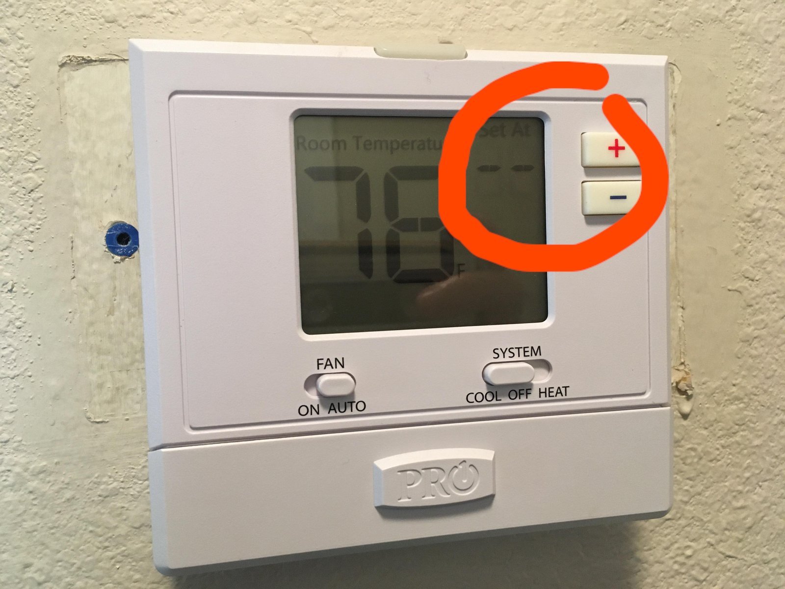 A modern thermostat mounted on a wall in a bright residential home.