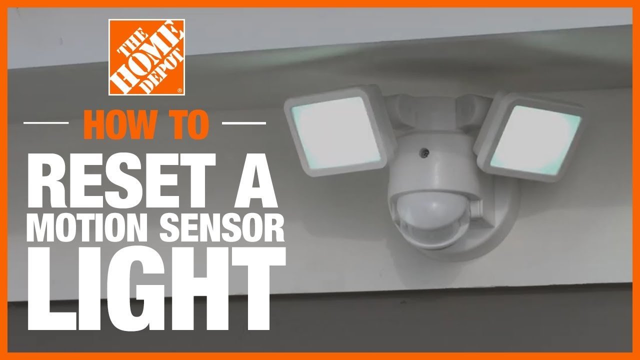 A modern motion detector light mounted on a brick wall during the twilight hour.