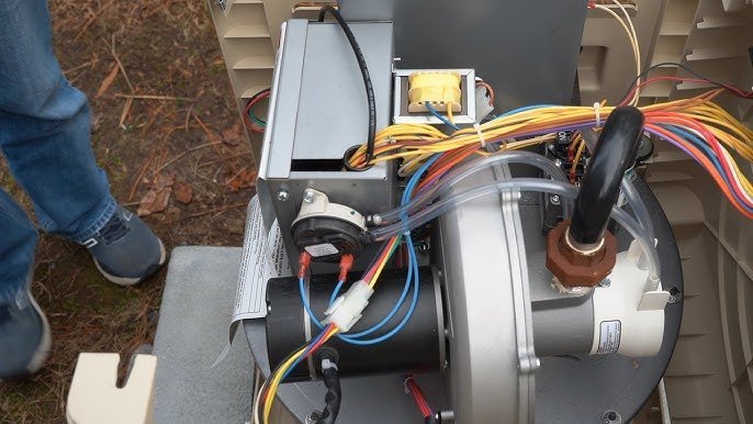A yellow gas shutoff valve in the open position on a pool heater pipe.