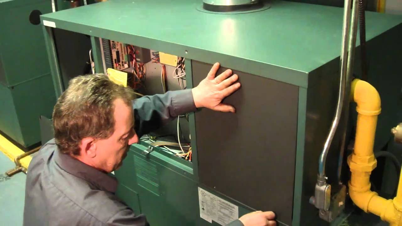 A technician performing routine maintenance on a Y-strainer in a heating system.