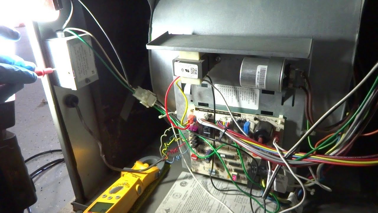 A technician performing a maintenance check on a modern Ruud Achiever 90 Plus furnace.