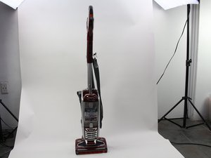 A modern Shark DuoClean vacuum cleaner stands in a clean, sunlit living room.