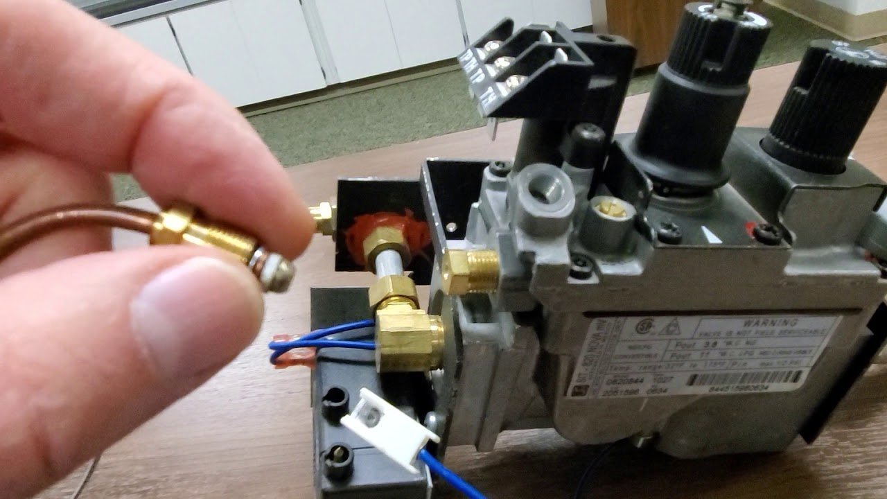 A detailed view of a Sit Nova 820 gas valve inside a fireplace.