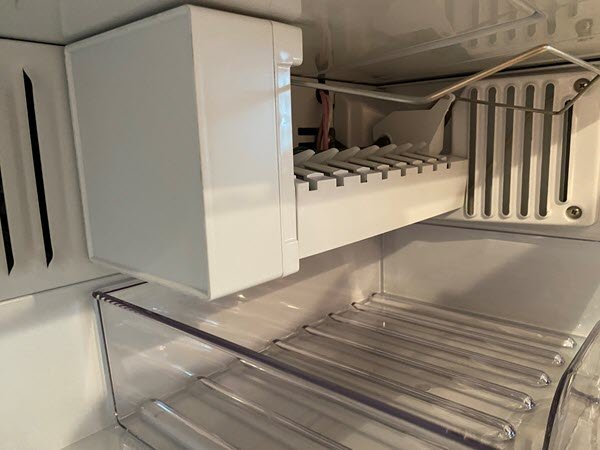A frozen water inlet tube inside a freezer causing ice maker issues.