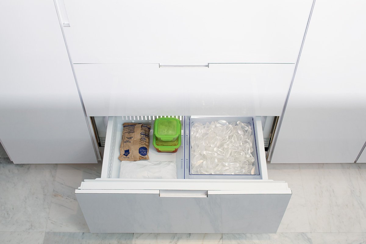 A modern Sub Zero refrigerator integrated into a bright and clean kitchen space.
