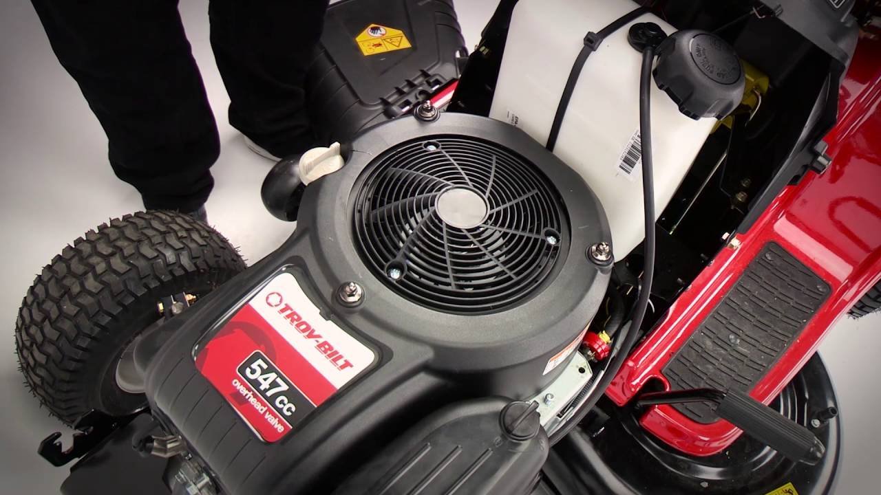 Cleaning dried grass from a mower safety switch to fix starting issues.