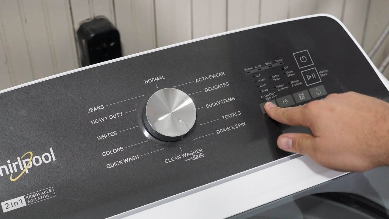 An uneven load of laundry inside a top-load washing machine drum.